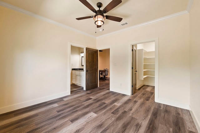 unfurnished bedroom with dark wood-type flooring, visible vents, crown molding, and baseboards