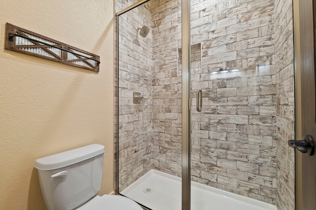 full bathroom featuring toilet and a shower stall