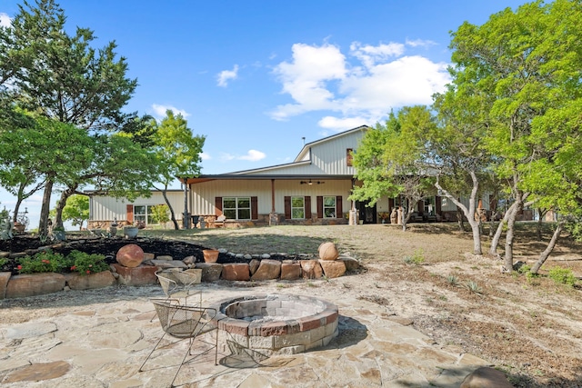 rear view of property featuring a patio area and an outdoor fire pit