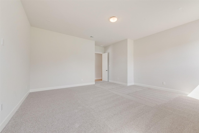 unfurnished room featuring visible vents, light carpet, and baseboards