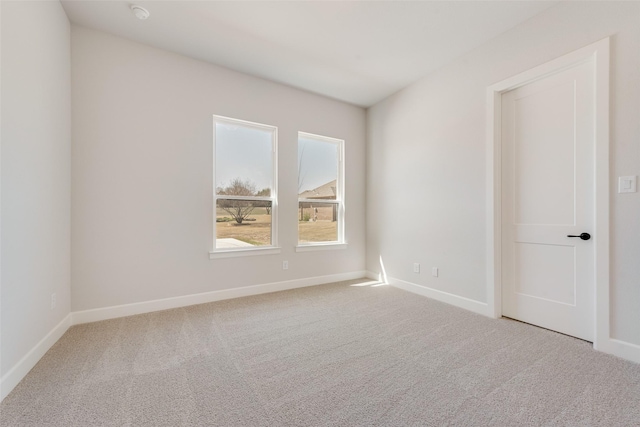 spare room featuring carpet and baseboards