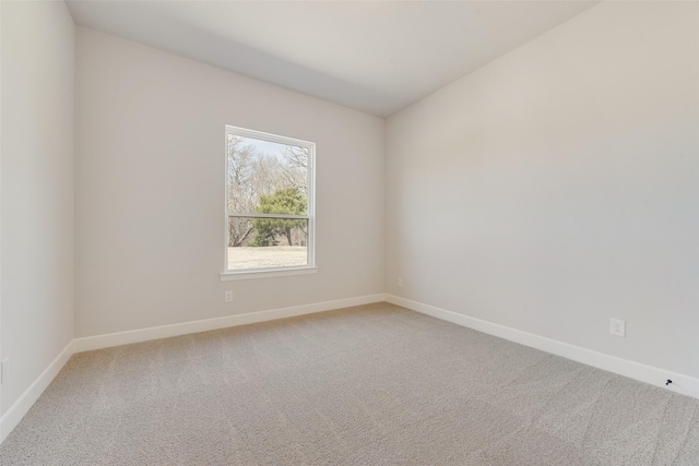 unfurnished room with baseboards and light colored carpet