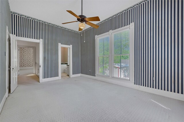 bathroom with a shower stall, wainscoting, wallpapered walls, and vanity