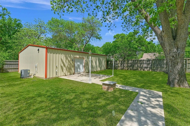 view of yard with a fenced backyard, an outdoor structure, a patio area, and central AC