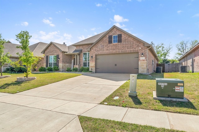traditional-style home featuring a garage, brick siding, a front yard, and central AC unit
