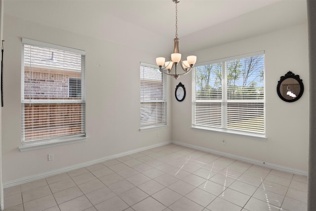unfurnished room featuring a chandelier, a healthy amount of sunlight, baseboards, and light tile patterned floors