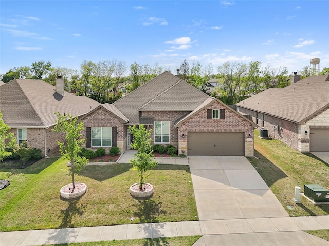 view of front of house featuring an attached garage, brick siding, cooling unit, and driveway