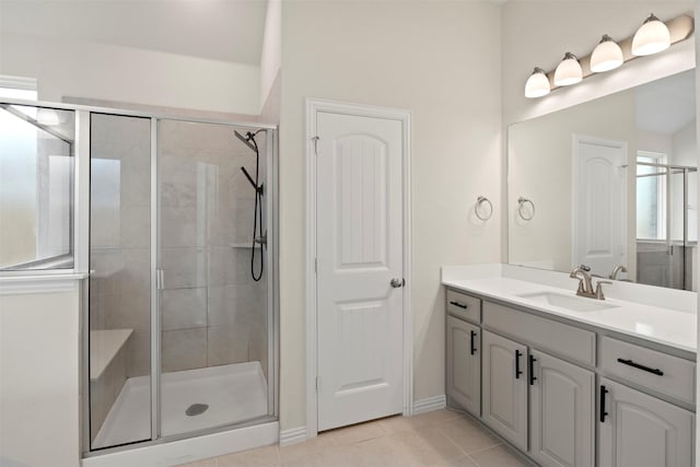 bathroom with baseboards, vanity, tile patterned flooring, and a stall shower