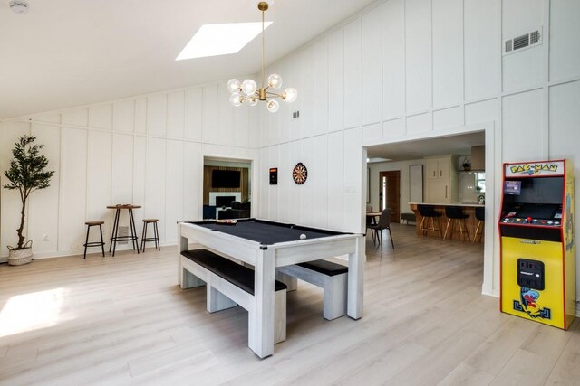 4043 Flintridge Dr, Dallas, TX 75244 - rec room with high vaulted ceiling, a decorative wall, light wood finished floors, and a skylight