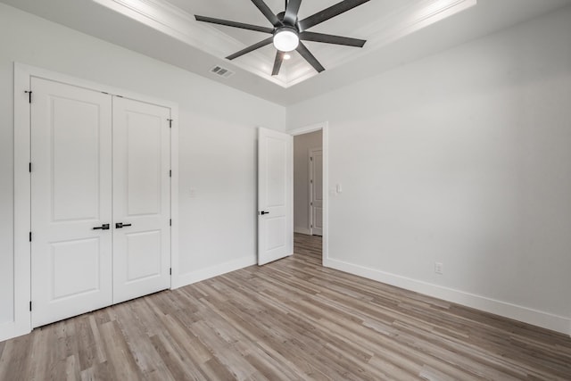 unfurnished bedroom featuring a closet, visible vents, light wood finished floors, and baseboards