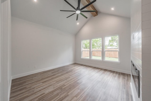 unfurnished living room featuring baseboards, a ceiling fan, wood finished floors, and beam ceiling