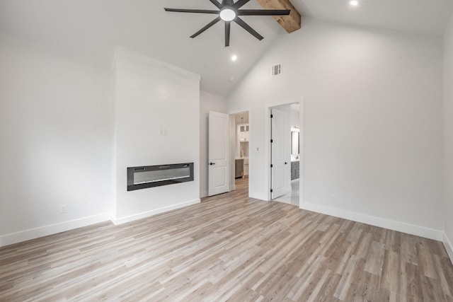 unfurnished living room with beam ceiling, a glass covered fireplace, visible vents, ceiling fan, and high vaulted ceiling