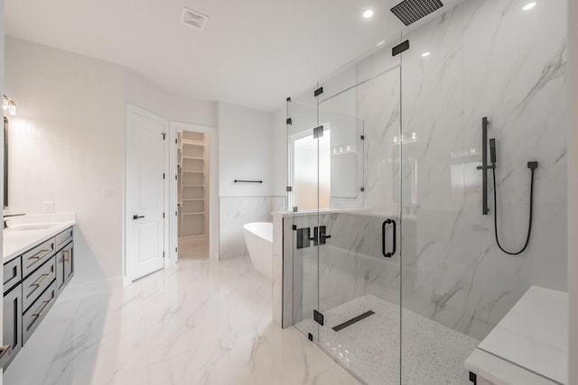 full bath featuring a marble finish shower, a freestanding bath, visible vents, marble finish floor, and vanity
