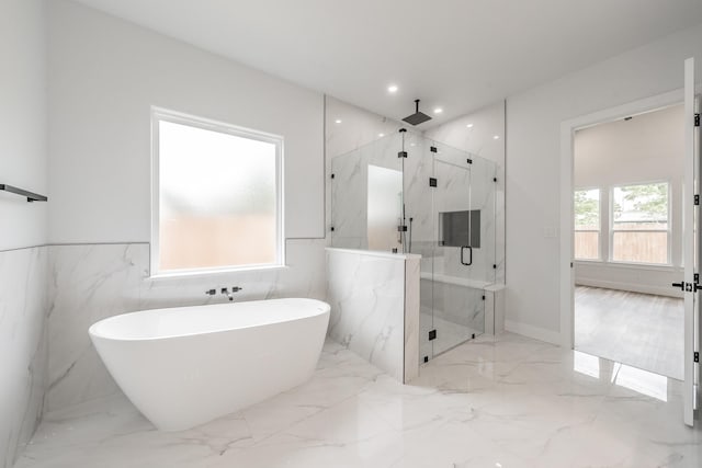 full bathroom with tile walls, a marble finish shower, marble finish floor, and a freestanding bath