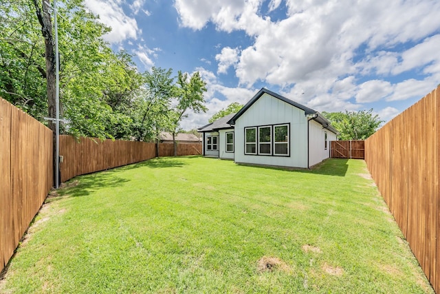 back of property with a fenced backyard and a yard