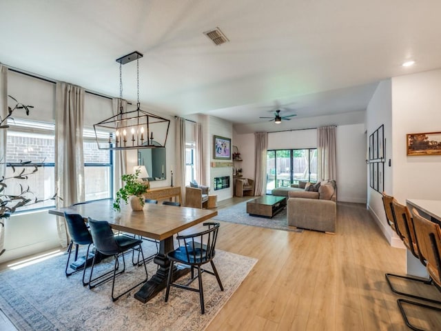 dining area with baseboards, visible vents, light wood-style floors, a notable chandelier, and stairway