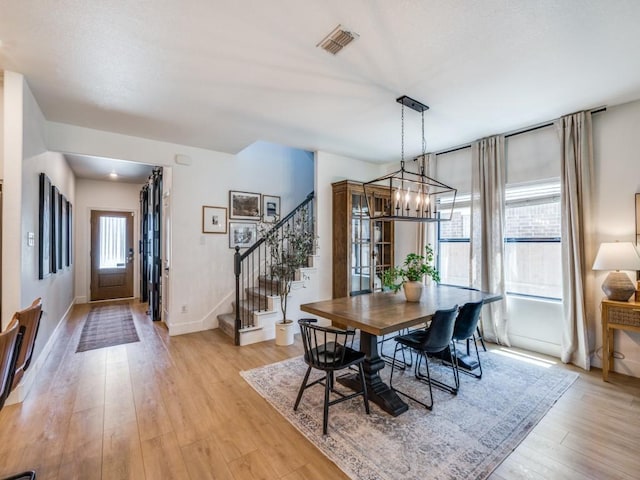 10041 Callan Ln, Fort Worth, TX 76131 - dining space featuring stairs, a chandelier, light wood-type flooring, and baseboards