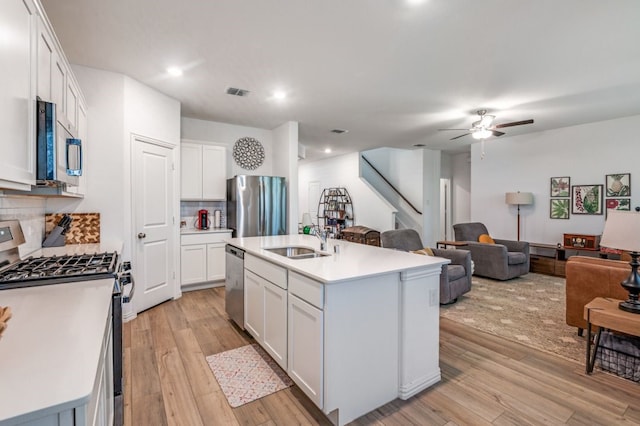 kitchen featuring a sink, appliances with stainless steel finishes, light wood-style flooring, and open floor plan