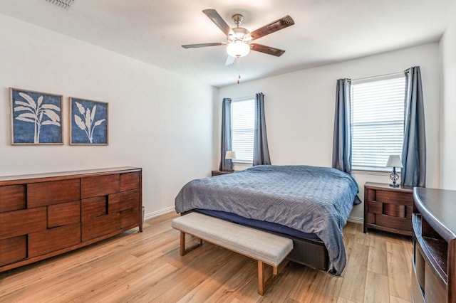 bedroom with baseboards, a ceiling fan, and light wood-style flooring