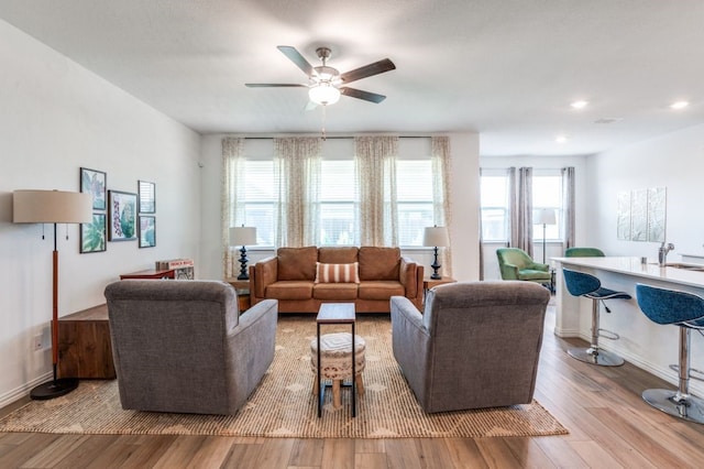 living room with a ceiling fan, baseboards, recessed lighting, and wood finished floors