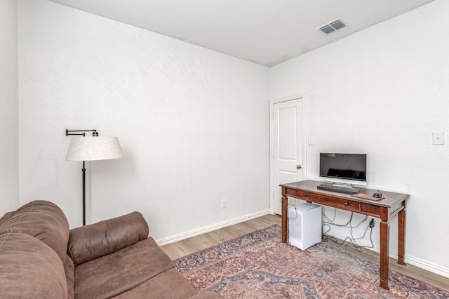 office with baseboards, visible vents, and wood finished floors