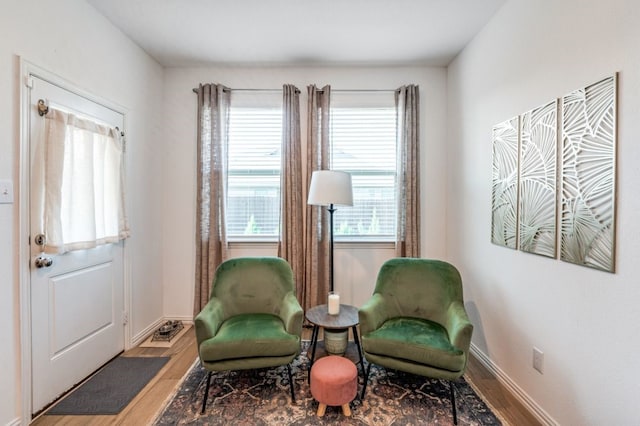 sitting room with baseboards and wood finished floors
