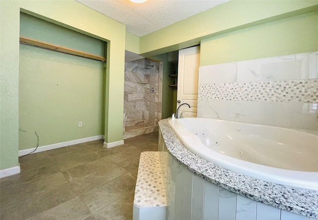 104 W Adkins St, Seagoville, TX 75159 - bathroom featuring a walk in shower, a tub with jets, a textured ceiling, and baseboards