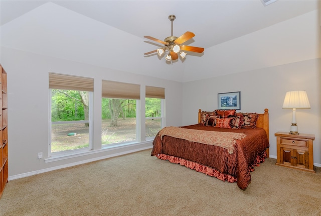 carpeted bedroom featuring a ceiling fan, vaulted ceiling, and baseboards