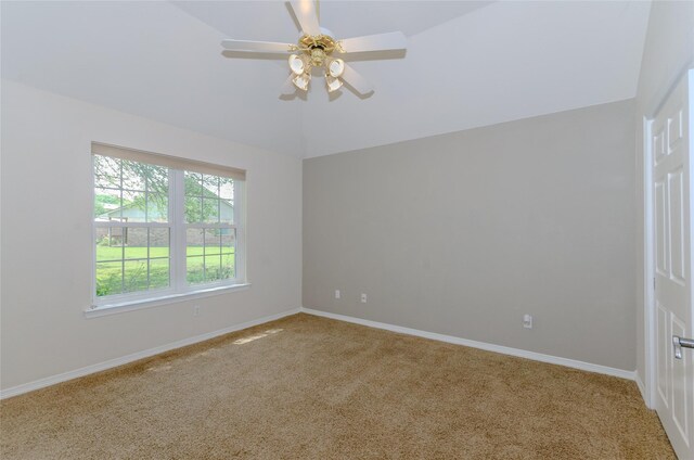 unfurnished room featuring a ceiling fan, vaulted ceiling, carpet, and baseboards