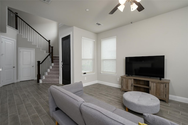 living area with stairway, baseboards, and wood tiled floor