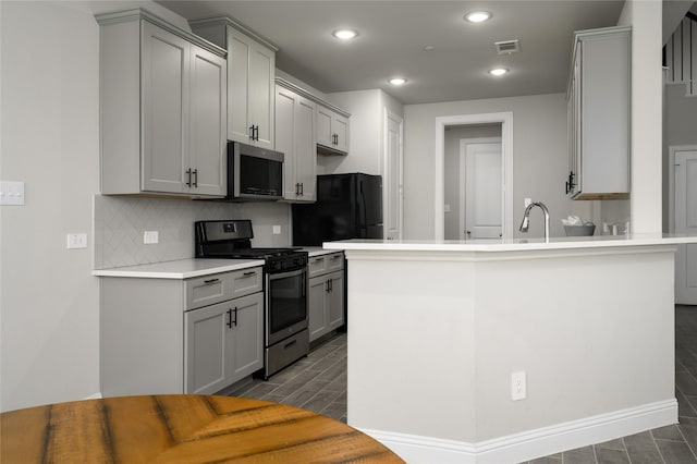 kitchen featuring visible vents, wood tiled floor, gray cabinetry, and stainless steel appliances