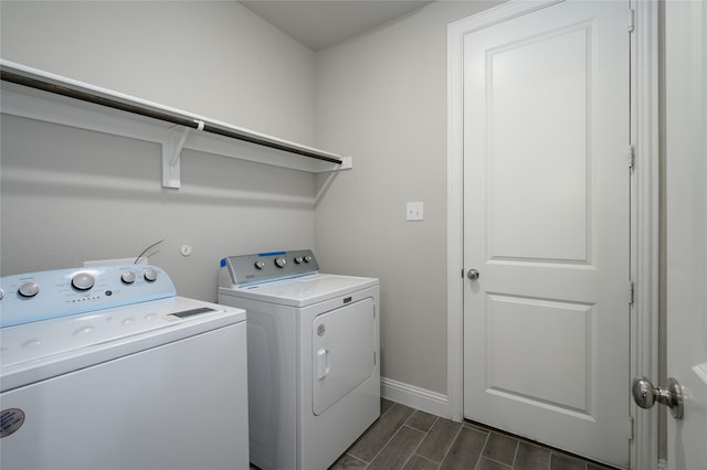 washroom featuring wood finish floors, laundry area, washing machine and dryer, and baseboards
