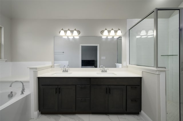 bathroom with a sink, a garden tub, double vanity, and marble finish floor