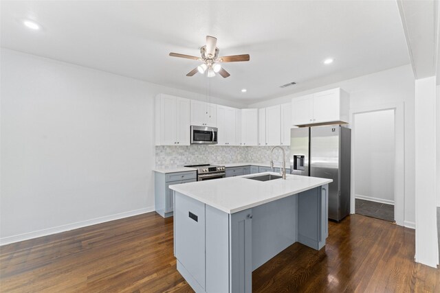 kitchen featuring stainless steel appliances, backsplash, light countertops, a sink, and ceiling fan