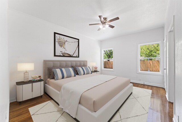 bedroom with wood finished floors, a ceiling fan, and baseboards