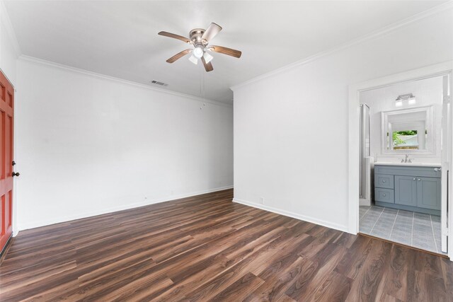 unfurnished bedroom featuring visible vents, crown molding, dark wood-style flooring, and connected bathroom