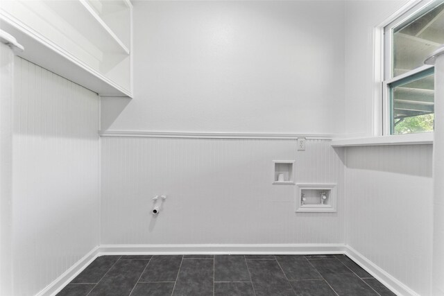 washroom with wainscoting, dark tile patterned floors, and laundry area
