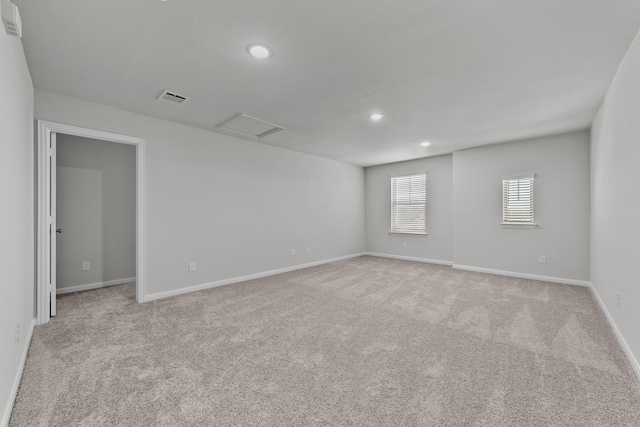 unfurnished room with attic access, baseboards, visible vents, recessed lighting, and light colored carpet