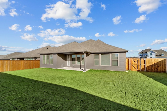 back of house featuring a lawn, a fenced backyard, and a patio