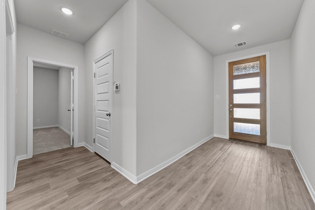 foyer entrance featuring light wood finished floors, baseboards, visible vents, and recessed lighting