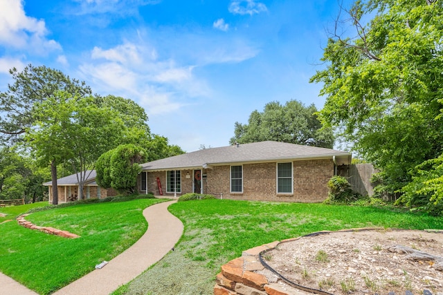 back of house featuring fence, a yard, and brick siding