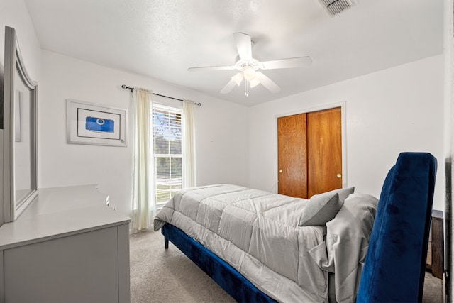 bedroom featuring ceiling fan, light colored carpet, and visible vents