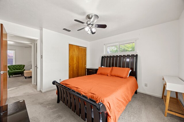 carpeted bedroom with visible vents, a ceiling fan, baseboards, and a closet