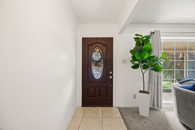 foyer entrance featuring crown molding, baseboards, and light tile patterned flooring