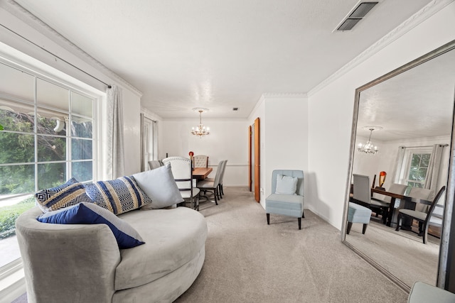 living room featuring crown molding, a chandelier, light carpet, and visible vents