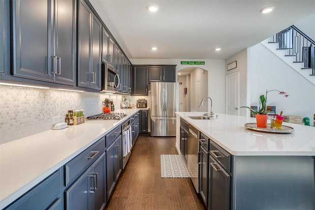 16900 Sophora Ave, Justin, TX 76247 - kitchen featuring a sink, an island with sink, light countertops, appliances with stainless steel finishes, and dark wood-style floors