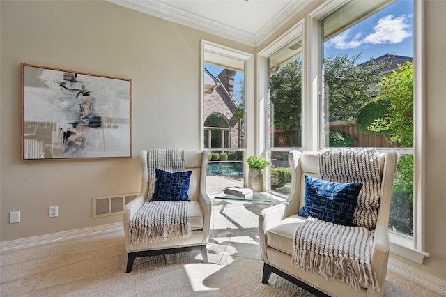 living area featuring baseboards, crown molding, visible vents, and carpet