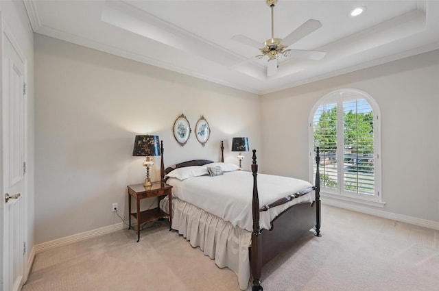 bedroom featuring light carpet, a raised ceiling, and crown molding