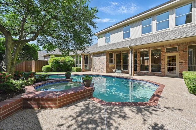 view of swimming pool with fence, a patio area, a fenced in pool, and an in ground hot tub