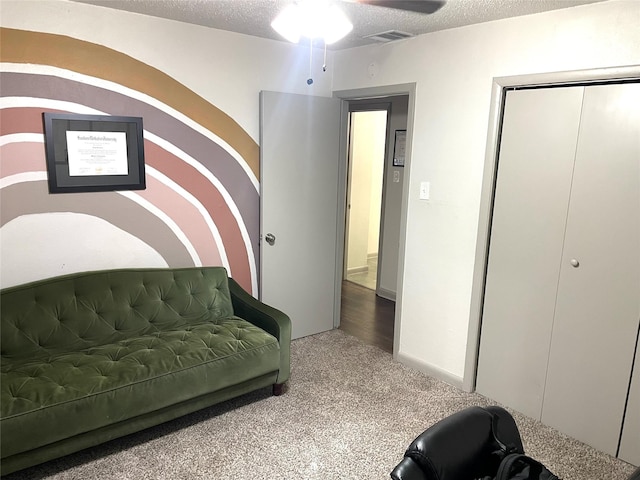 interior space with visible vents, a textured ceiling, carpet, and ceiling fan